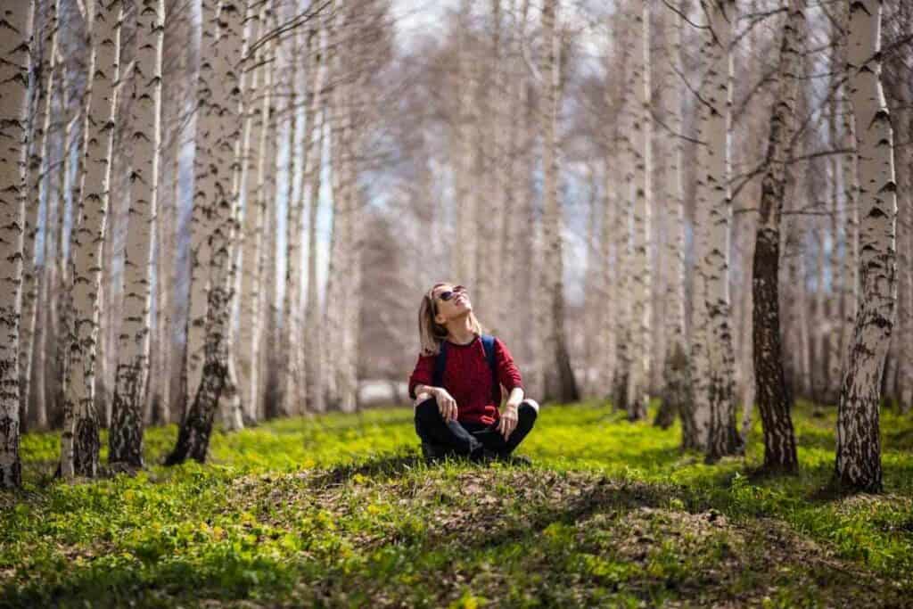 Tiny forest: una donna seduta al centro di una foresta