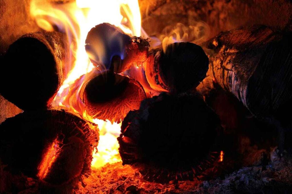 Riscaldare casa senza termosifoni: della legna brucia in un camino